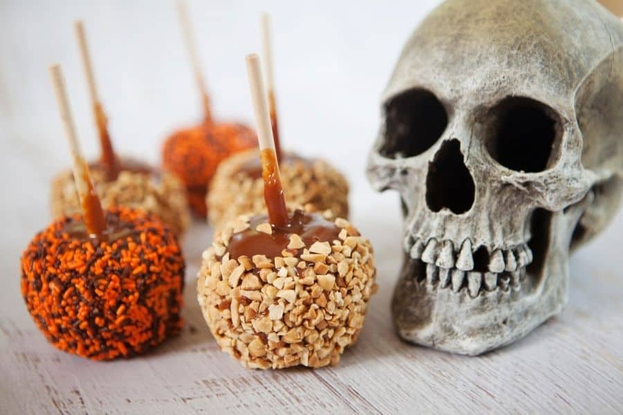  caramel apples with a skull beside them