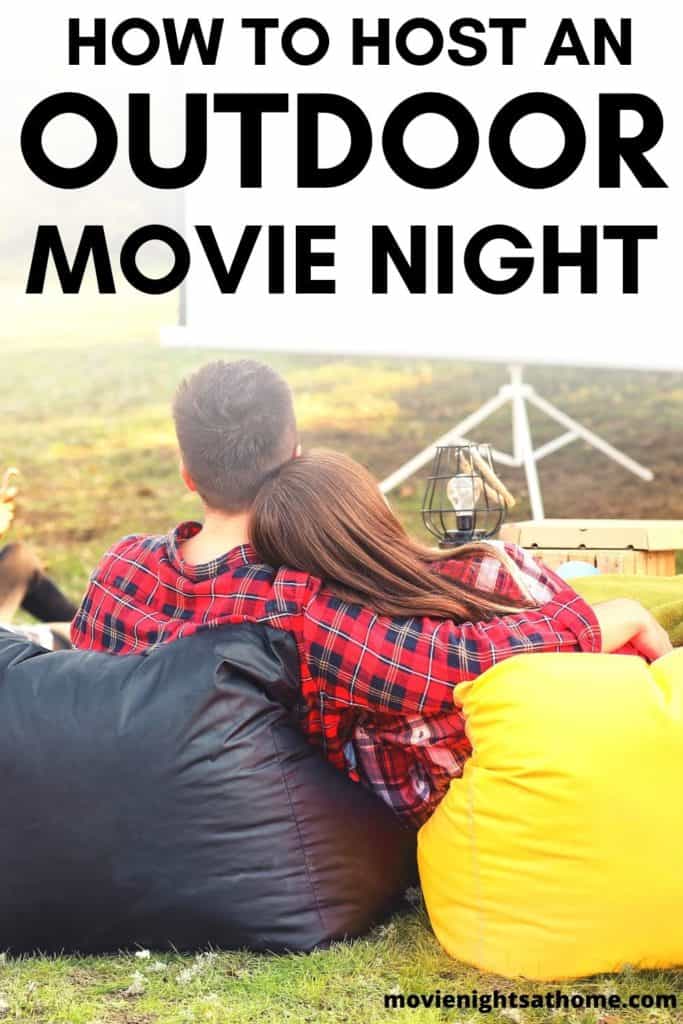 Couple outside watching a movie at dusk - Text overlay "How to Host an Outdoor Movie Night"