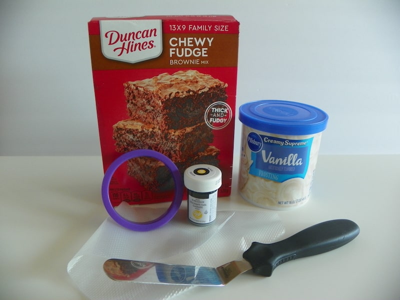 brownie mix, frosting, cooking cutter, spreader, and black food coloring