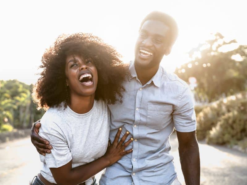 black couple laughing and hugging each other