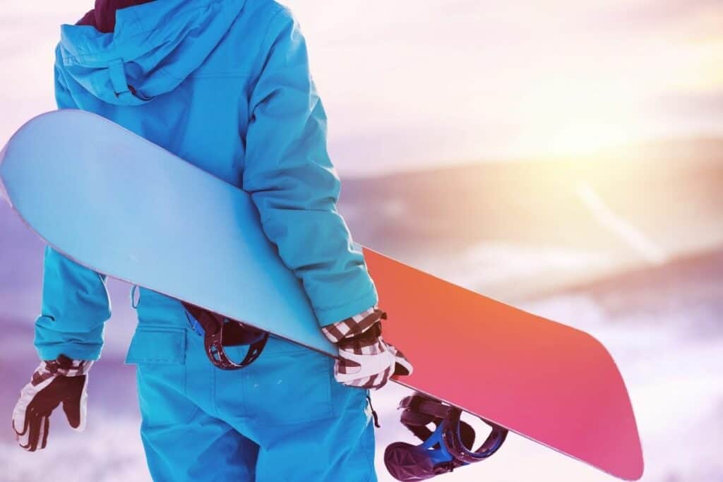 close up of a woman holding her snowboard