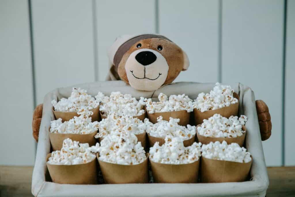 small bowls of popular with a stuffed teddy bear behind them