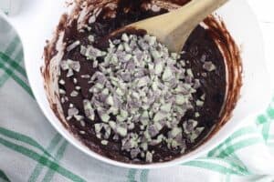 bowl of brownie mix with the mint baking chips mixing in