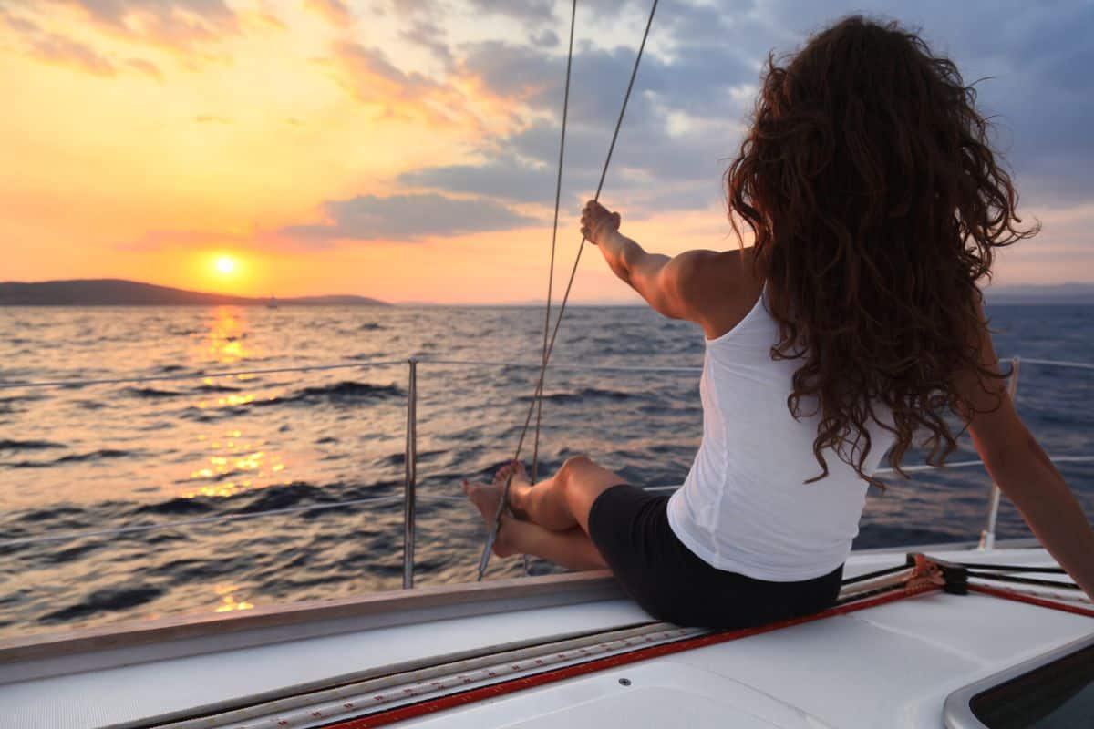 woman on a sail boat at sunset