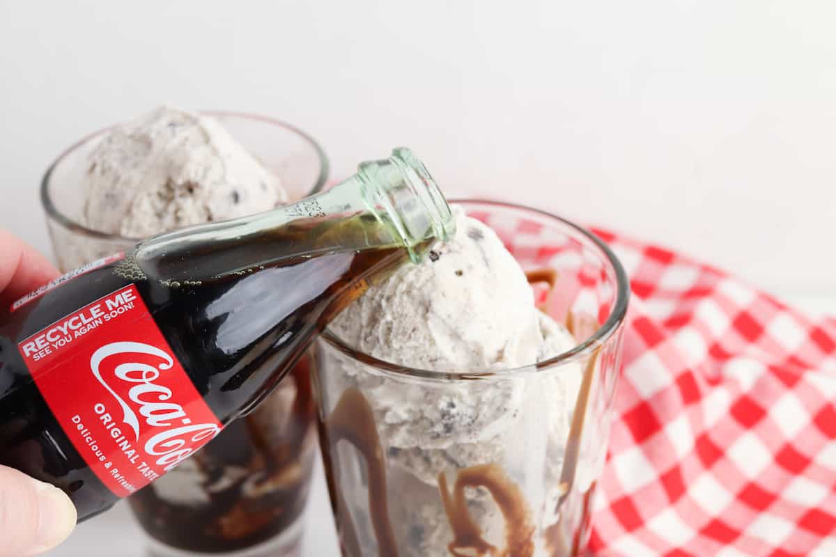 coke being poured over cookies and cream ice cream