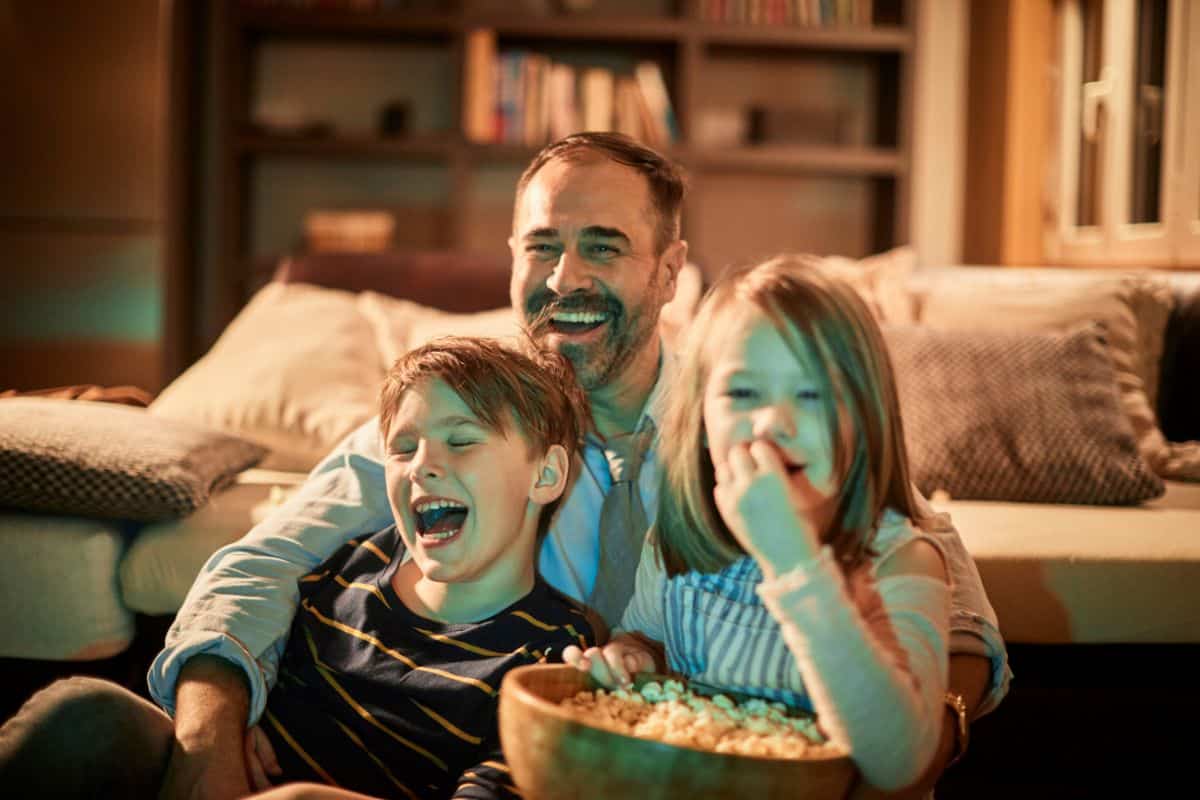 dad watching movie with his 2 kids