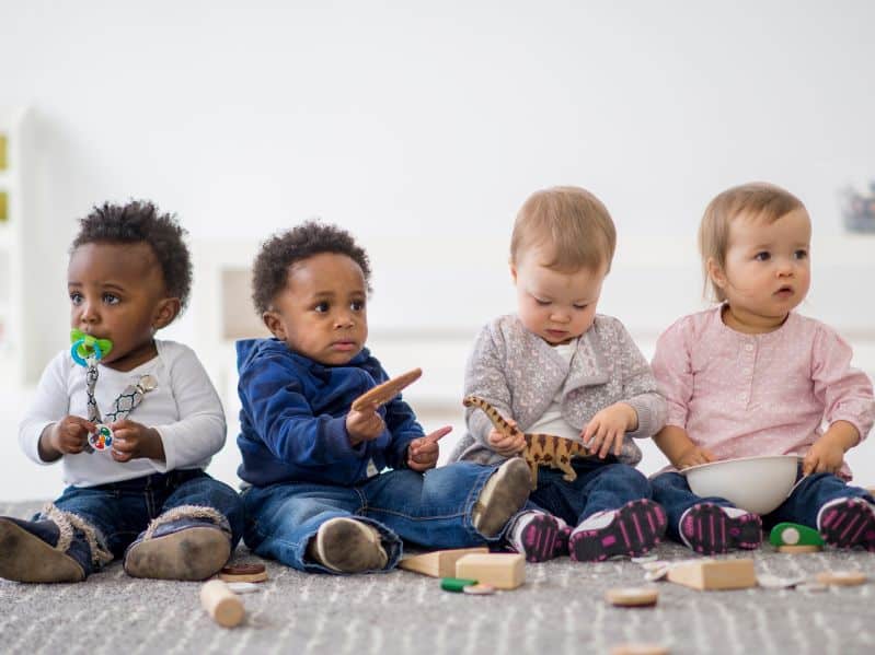 4 babies sitting together playing