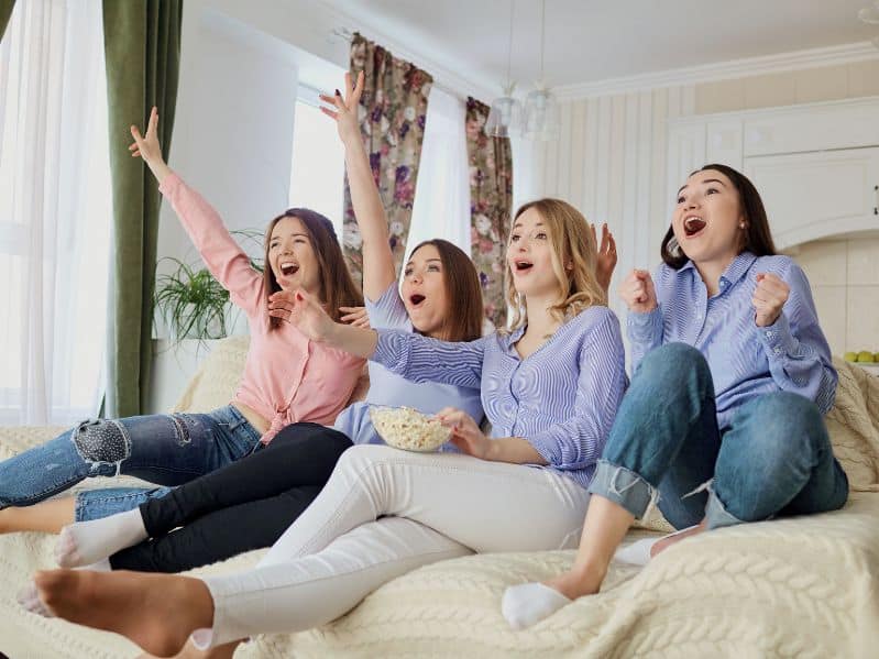 4 girls watching a movie from our list of the best teen movies on disney plus