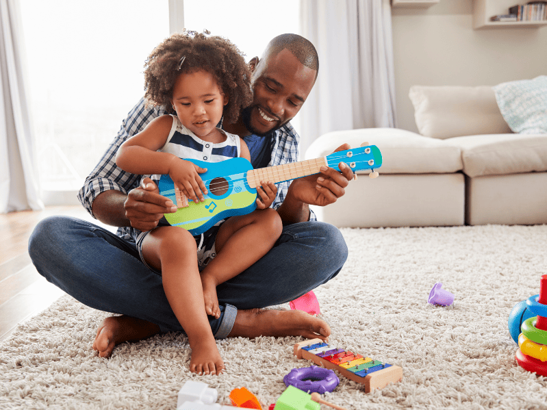 dad with his toddler playing guitar