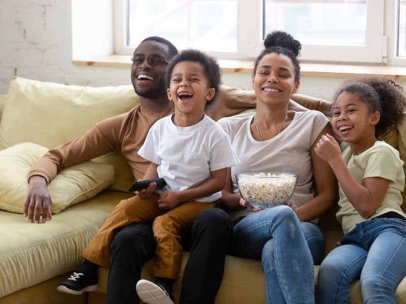 family of 4 watching disney+ together on the couch