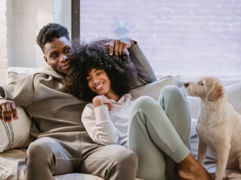 couple on couch w dog happy